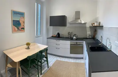 a kitchen with a wooden table and a counter top at Superbe appartement centre ville Ajaccio in Ajaccio