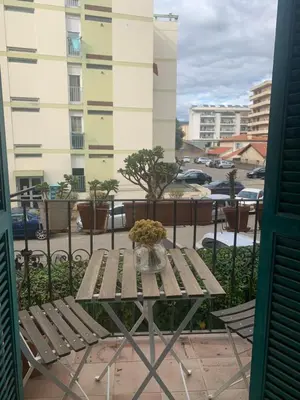 a table with a vase of flowers on a balcony at Superbe appartement centre ville Ajaccio in Ajaccio
