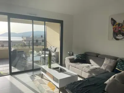 a living room with a couch and a table at Splendide T3 neuf au bord de la plage in Propriano