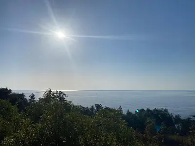 a view of the ocean with the sun in the sky at Bas de villa - Canella in Sari Solenzara