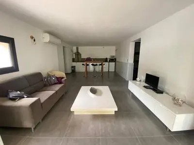 a living room with a couch and a table at Bas de villa - Canella in Sari Solenzara