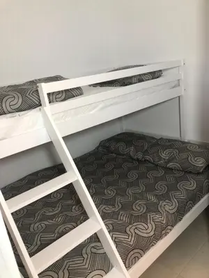 two white bunk beds in a room with a carpet at Casa Virginia in Santa-Lucia-di-Moriani
