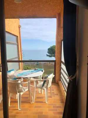 a balcony with a table and chairs and a view of the ocean at Casa Virginia in Santa-Lucia-di-Moriani