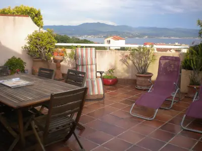 a patio with a wooden table and chairs at Chambre hôtes Wagram in Ajaccio