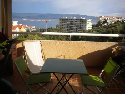 a table and chairs on a balcony with a view at Chambre hôtes Wagram in Ajaccio
