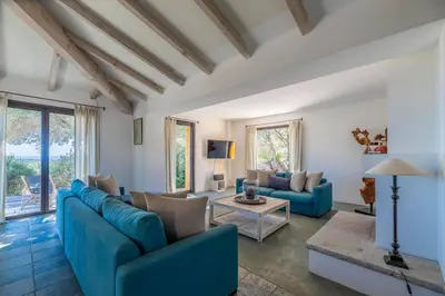 a living room with blue couches and a table at Villa Sud Corse 6ch piscine 27m, accès mer in Pianottoli-Caldarello