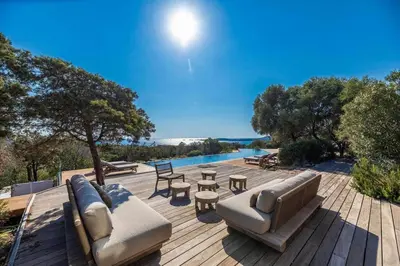 a patio with a couch and tables and a pool at Villa Sud Corse 6ch piscine 27m, accès mer in Pianottoli-Caldarello