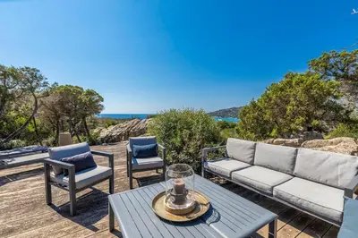 a patio with a couch and two chairs and a table at Villa Sud Corse 6ch piscine 27m, accès mer in Pianottoli-Caldarello