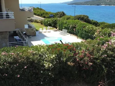 a house with a swimming pool next to the ocean at Grand appartement T4, piscine, vue exceptionnelle à 50 m de la plage in Propriano