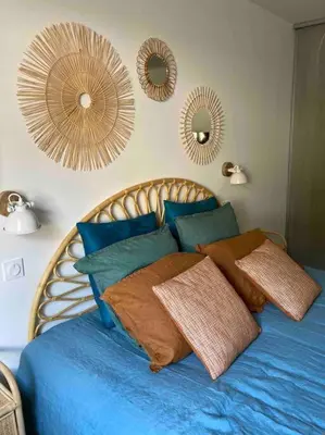 a bedroom with a blue bed with mirrors on the wall at Vignarella meublé de tourisme classé 5 étoiles avec terrasse in Piana