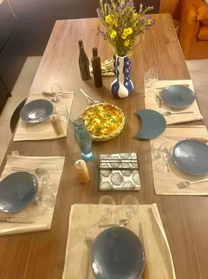 a wooden table with plates and dishes on it at Vignarella meublé de tourisme classé 5 étoiles avec terrasse in Piana