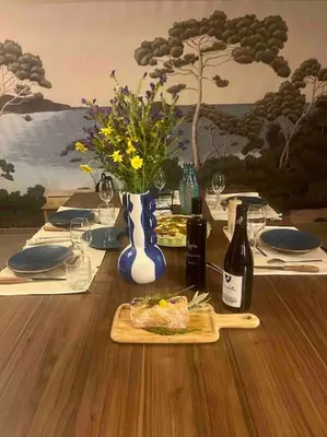 a table with a plate of food and bottles of wine at Vignarella meublé de tourisme classé 5 étoiles avec terrasse in Piana