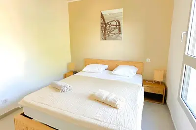 a bedroom with two beds with white sheets and towels at Duplex Marina Di Cala Rossa in Lecci