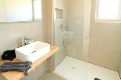 a white bathroom with a sink and a shower at Duplex Marina Di Cala Rossa in Lecci