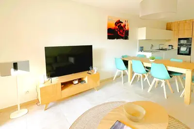 a living room with a television and a table and chairs at Duplex Marina Di Cala Rossa in Lecci