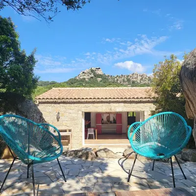 two blue chairs sitting in front of a house at Bergerie U Caseddu in Pianottoli-Caldarello
