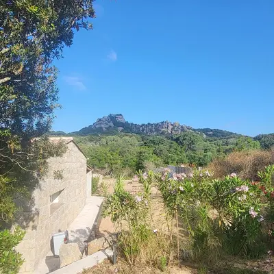 a stone building with a mountain in the background at Bergerie U Caseddu in Pianottoli-Caldarello