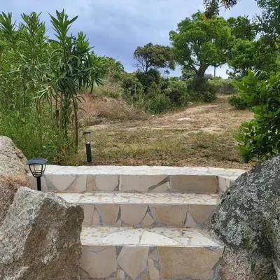 a set of stone steps with trees in the background at Bergerie U Caseddu in Pianottoli-Caldarello