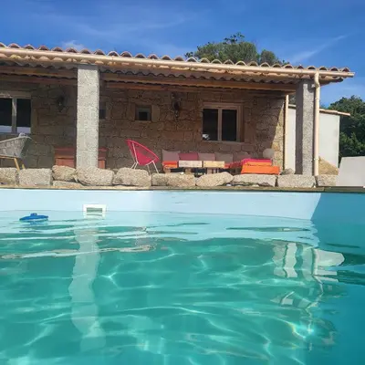 a swimming pool in front of a house at Bergerie U Caseddu in Pianottoli-Caldarello