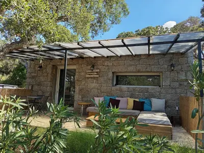 a patio with a couch under a pergola at La RoseDan in Pianottoli-Caldarello
