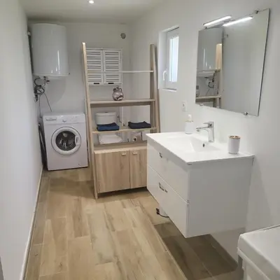 a bathroom with a sink and a washing machine at La RoseDan in Pianottoli-Caldarello