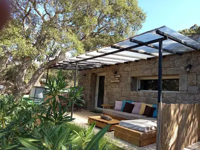 a patio with a couch under a pergola at La RoseDan in Pianottoli-Caldarello