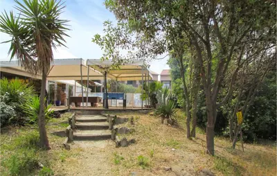 a house with stairs and trees in front of it at Lovely Apartment In Moriani Plage in Moriani Plage