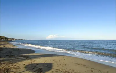a beach with the ocean on a sunny day at Lovely Apartment In Moriani Plage in Moriani Plage