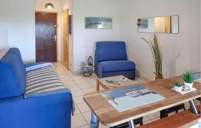 a living room with a blue couch and a table at Lovely Apartment In Moriani Plage in Moriani Plage