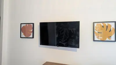 a flat screen tv hanging on a wall with three pictures at U Maestrale in Canale-di-Verde