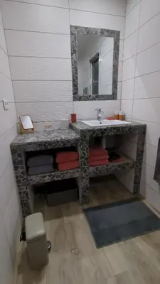 a bathroom with a stone sink and a mirror at U Maestrale in Canale-di-Verde