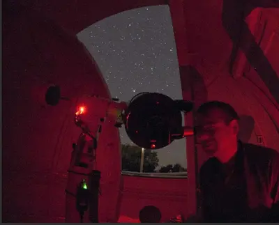a man looking at the stars through a telescope at Gîtes et Astrotourisme en Corse in Erbajolo