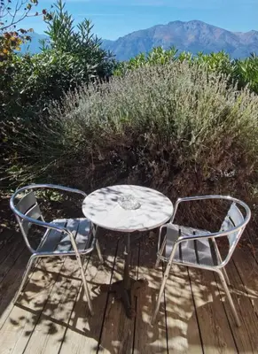 a table and two chairs sitting on a wooden deck at Gîtes et Astrotourisme en Corse in Erbajolo