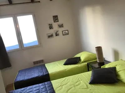 a bedroom with two beds and a window at Gîtes et Astrotourisme en Corse in Erbajolo