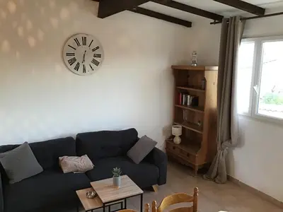 a living room with a couch and a clock on the wall at Gîtes et Astrotourisme en Corse in Erbajolo