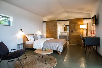 a hotel room with a bed and a table and chairs at Hotel Les Chambres de Mila Bonifacio in Bonifacio