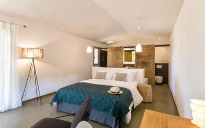 a bedroom with a large bed with a blue blanket at Hotel Les Chambres de Mila Bonifacio in Bonifacio