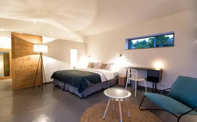 a bedroom with a bed and a table and a chair at Hotel Les Chambres de Mila Bonifacio in Bonifacio