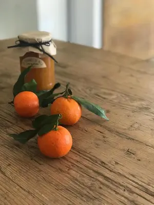 four oranges on a table with a jar of honey at Hotel Les Chambres de Mila Bonifacio in Bonifacio