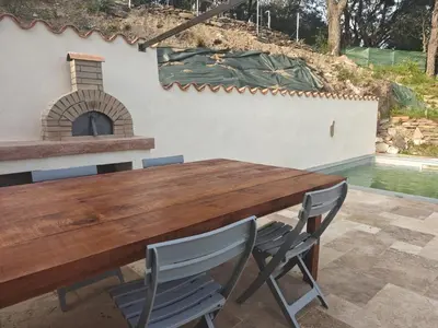 a wooden table and chairs with a fireplace at Maison avec vue sur la mer et piscine in Talasani