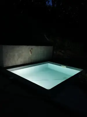 a butterfly sitting on top of a table in the dark at Maison avec vue sur la mer et piscine in Talasani