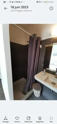 a bathroom with a shower curtain and a sink at Maison avec vue sur la mer et piscine in Talasani