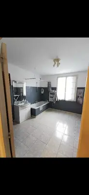 a large room with a kitchen with a ceiling fan at Maison avec vue sur la mer et piscine in Talasani
