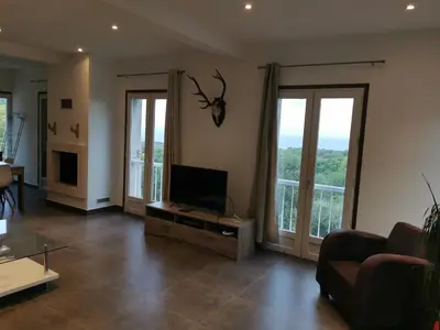 a living room with a flat screen tv on a table at Maison avec vue sur la mer et piscine in Talasani