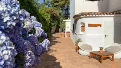 a walkway with purple flowers and a table and chairs at A'mare Corsica I Seaside Small Resort in Propriano
