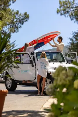 a group of people getting out of a car with a surfboard on top at A'mare Corsica I Seaside Small Resort in Propriano