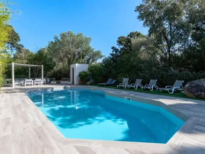 a swimming pool with blue water in a yard at Villa Villa Romana by Interhome in Porto-Vecchio