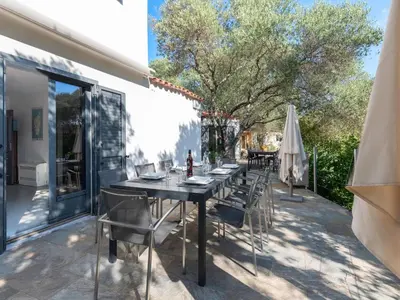 a dining table and chairs on a patio at Villa Villa Romana by Interhome in Porto-Vecchio