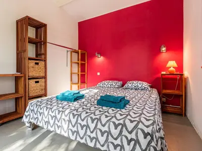 a bedroom with a large bed with a red wall at Villa Villa Romana by Interhome in Porto-Vecchio
