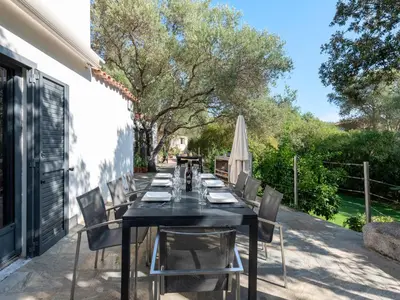 a long black table with chairs on a patio at Villa Villa Romana by Interhome in Porto-Vecchio